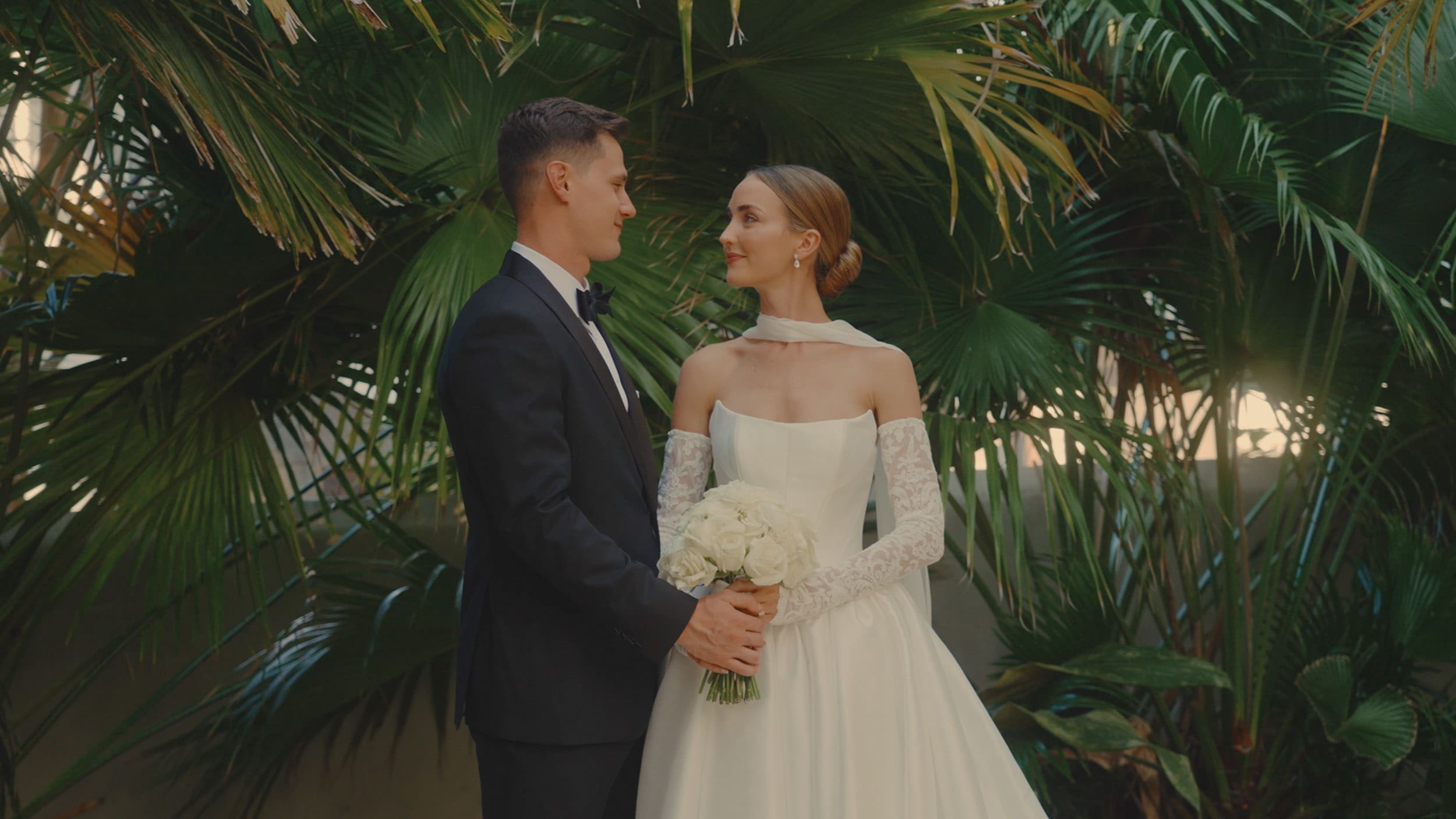 man and women in wedding attire looking at each other